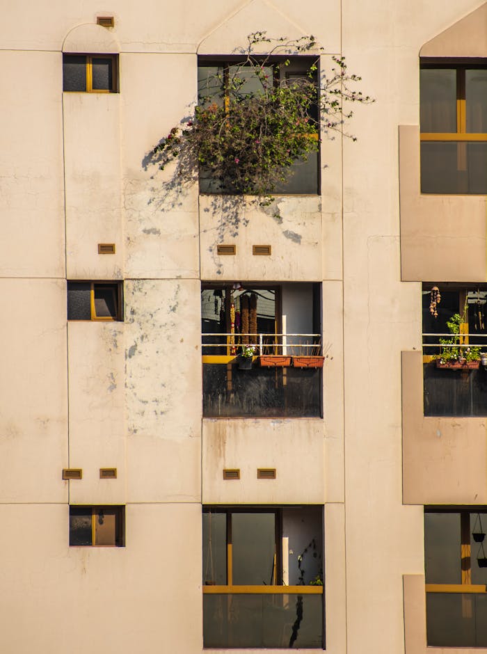 Close-up of a modern urban apartment facade with small balconies and windows.